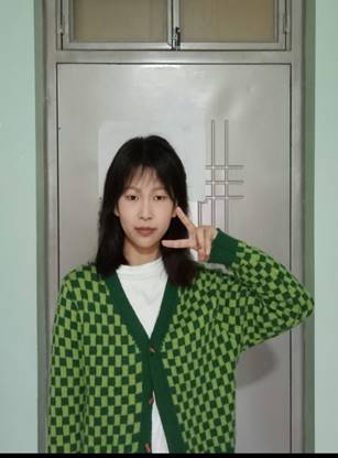 穿绿色衣服的女人站在门前
描述已自动生成